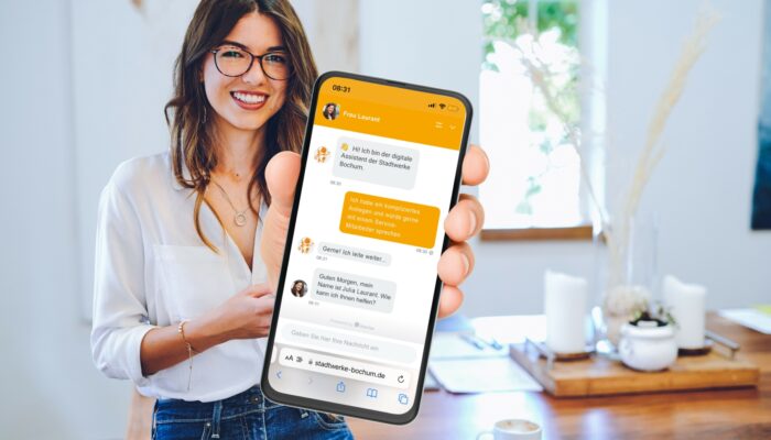 Frau hält iPhone mit offener Chatbot-Konversation in der Hand